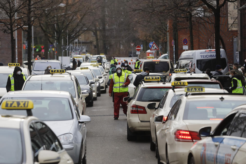 People as the arrive and departure with taxies at the vaccination center against the COVID-19 disease in the district Treptow in Berlin, Germany, Thursday, Jan. 28, 2021. (AP Photo/Markus Schreiber)