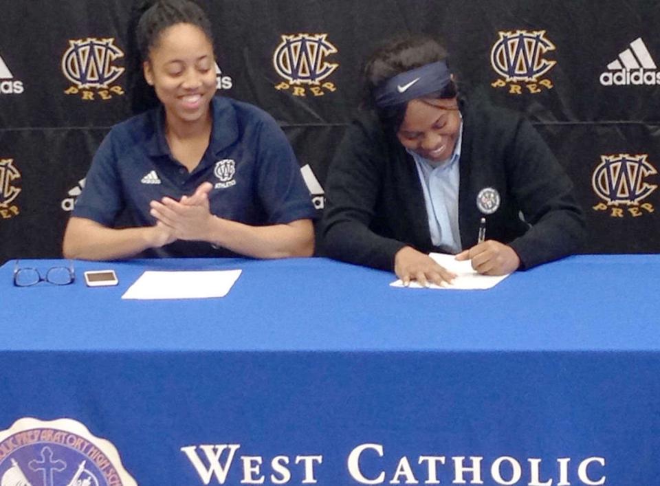 Beulah Osueke watches as Akyra Murray signs a letter of intent to Mercyhurst University in 2016. (Provided by Beulah Osueke) 