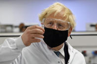 Britain's Prime Minister Boris Johnson holds a vial of the Oxford/AstraZeneca vaccine Covid-19 candidate vaccine, known as AZD1222, at Wockhardt's pharmaceutical manufacturing facility in Wrexham, Wales, Monday, Nov. 30, 2020. (Paul Ellis/PA via AP)