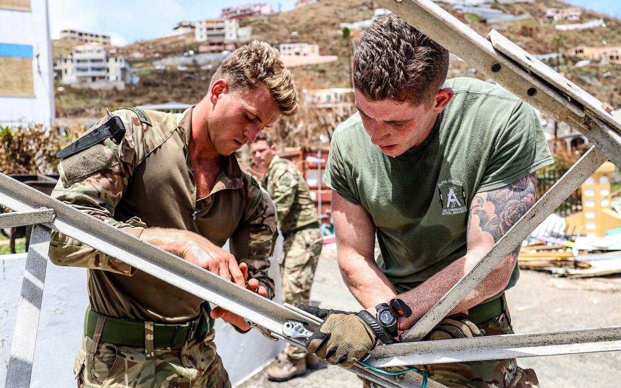 British Marines work to move a collapsed radio mast caused by Hurricane Irma within the police station on Tortola, British Virgin Islands - PA