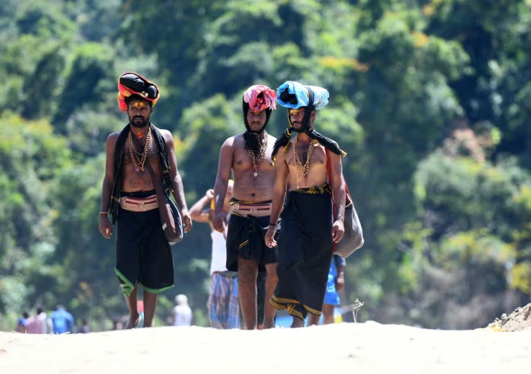 Pilgims visiting Sabarimala Temple, where tradition dictates women of menstruating age barred, carry ritual offerings of coconut and clarified butter on their heads