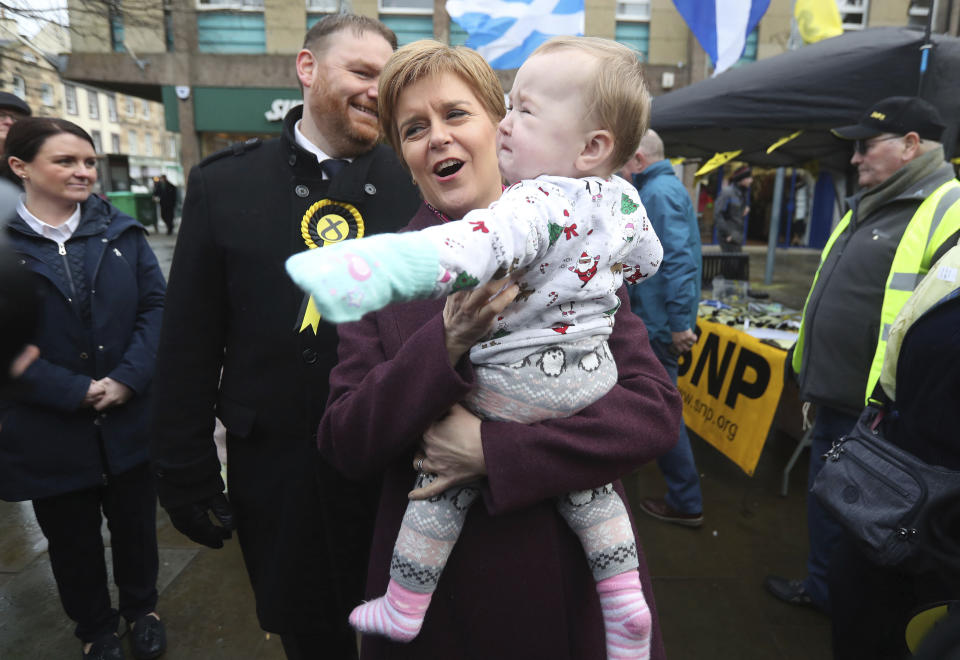 SNP leader Nicola Sturgeon holds a baby in Dalkeith, whilst on the General Election campaign trail in Midlothian, Scotland, Wednesday Dec. 4, 2019. Britain goes to the polls on Dec. 12. The independence of Scotland from the rest of the United Kingdom is not on the ballot, but it's uppermost on the minds of many voters here as they make their final choices ahead of the national election next week. (Andrew Milligan/PA via AP)