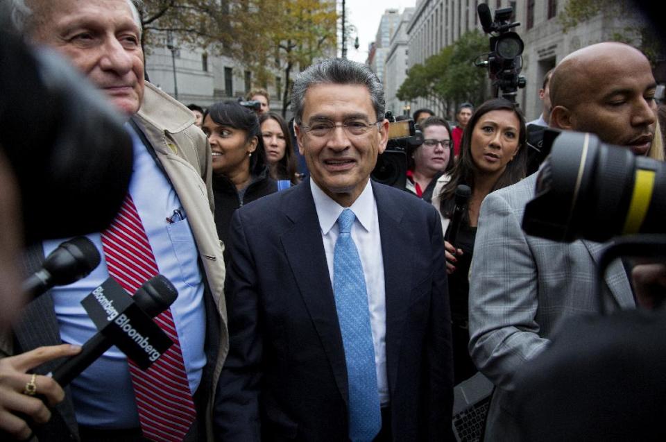 Rajat Gupta, center, leaves federal court in New York on Wednesday, Oct. 24, 2012 after the former Goldman Sachs and Procter & Gamble Co. board member was sentenced Wednesday to 2 years in prison for feeding inside information about board dealings with a billionaire hedge fund owner who was his friend. (AP Photo/Craig Ruttle)