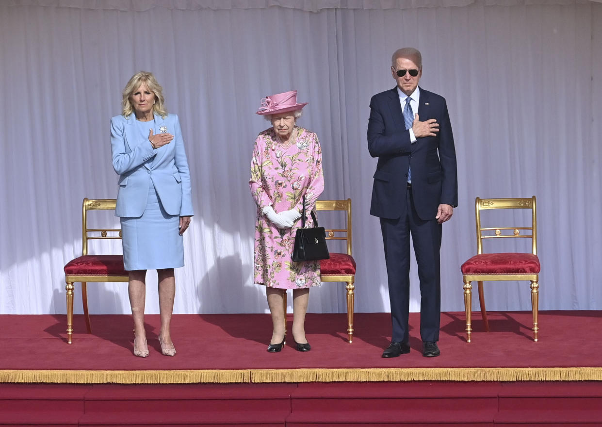 Her Majesty Queen Elizabeth II welcomes President Joe Biden and First Lady Jill Biden, with hands on their hearts, as the American national anthem is played.