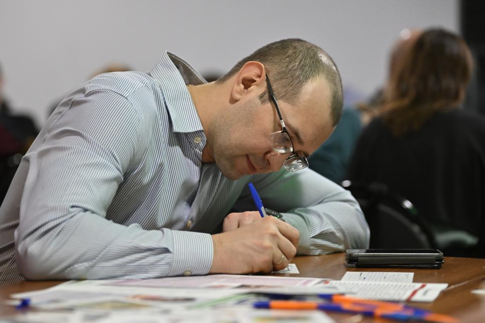 A man writes a letter to political prisoners in the office of the liberal party Yabloko in Moscow, Russia, Thursday, Feb. 29, 2024. Yabloko hosts monthly letter-writing evenings in cities across the country. With protests all but stifled, more and more Russians at home and abroad are seeking to help political prisoners by writing them letters. (AP Photo/Dmitry Serebryakov)