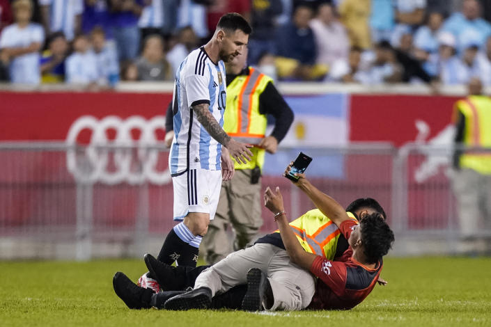 A fan is tackled as he tries to take a picture of Argentina's player Lionel Messi during the second half of an international friendly soccer match against Jamaica on Tuesday, Sept. 27, 2022, in Harrison, N.J. (AP Photo/Eduardo Munoz Alvarez)