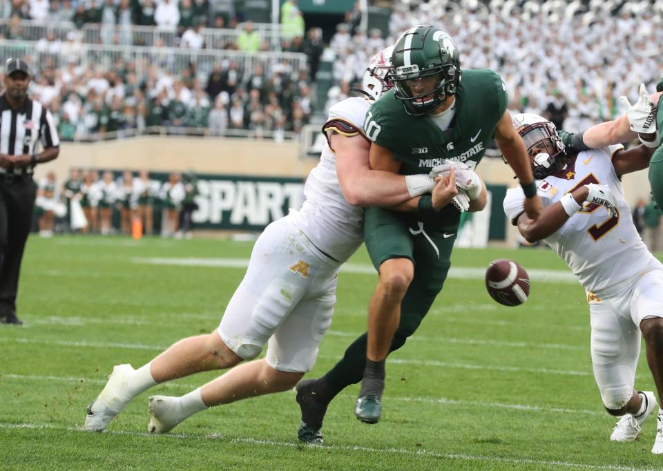 Michigan State Spartans quarterback Payton Thorne fumbles after being hit by Minnesota Golden Gophers defensive lineman Thomas Rush (8) during the second half at Spartan Stadium, Saturday, Sept. 24, 2022.