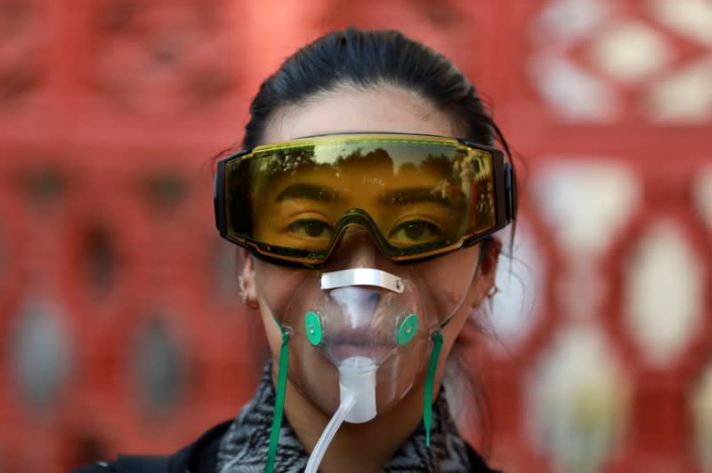 A woman wears a mask during an environmental activists' rally to demand rights to clean air, near the Thai Government House in Bangkok