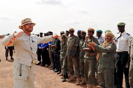 A Dutch peacekeeper speaks with Malian gendarmes and police in Gao, Mali, August 11, 2015. The United Nations has deployed 10,000 peacekeepers and poured more than $1 billion into Mali but its efforts to end a three-year conflict are threatened by the reemergence of a centuries-old rivalry between Tuareg clans. Picture taken August 11. To match Insight MALI-VIOLENCE/MILITIA REUTERS/Emma Farge