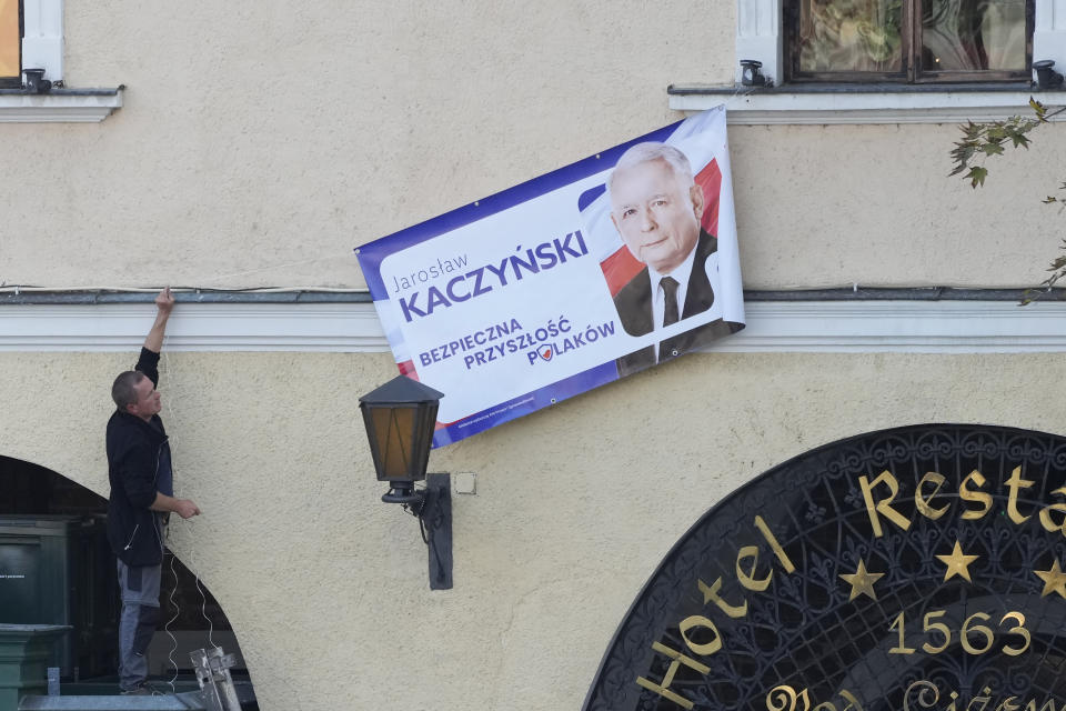 Workers hoisting campaign banner of ruling Law and Justice leader and Poland's most powerful politician, Jaroslaw Kaczynski, who is running in crucial parliamentary election, in Sandomierz, Poland, on Friday, Oct. 13, 2023. At stake in Sunday's vote are the health of the nation's democracy, strained under the ruling conservative Law and Justice party, and the foreign alliances of a country on NATO's eastern flank that has been a crucial ally. The main challenger is centrist Civic Coalition. (AP Photo/Czarek Sokolowski)