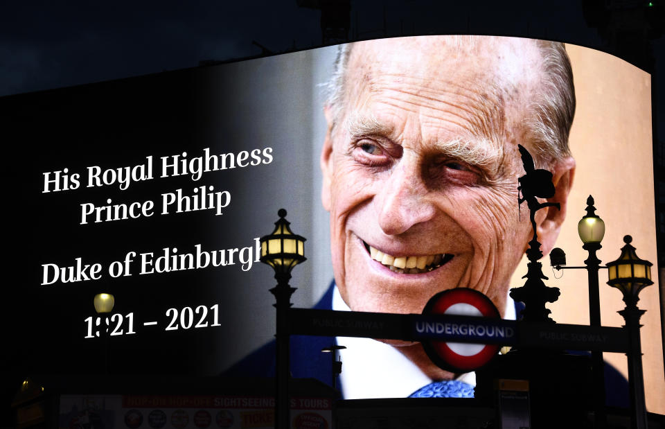 A tribute to Britain's Prince Philip is projected onto a large screen at Piccadilly Circus in London, Friday, April 9, 2021. Buckingham Palace officials say Prince Philip, the husband of Queen Elizabeth II, has died. He was 99. Philip spent a month in hospital earlier this year before being released on March 16 to return to Windsor Castle. (AP Photo/Alberto Pezzali)