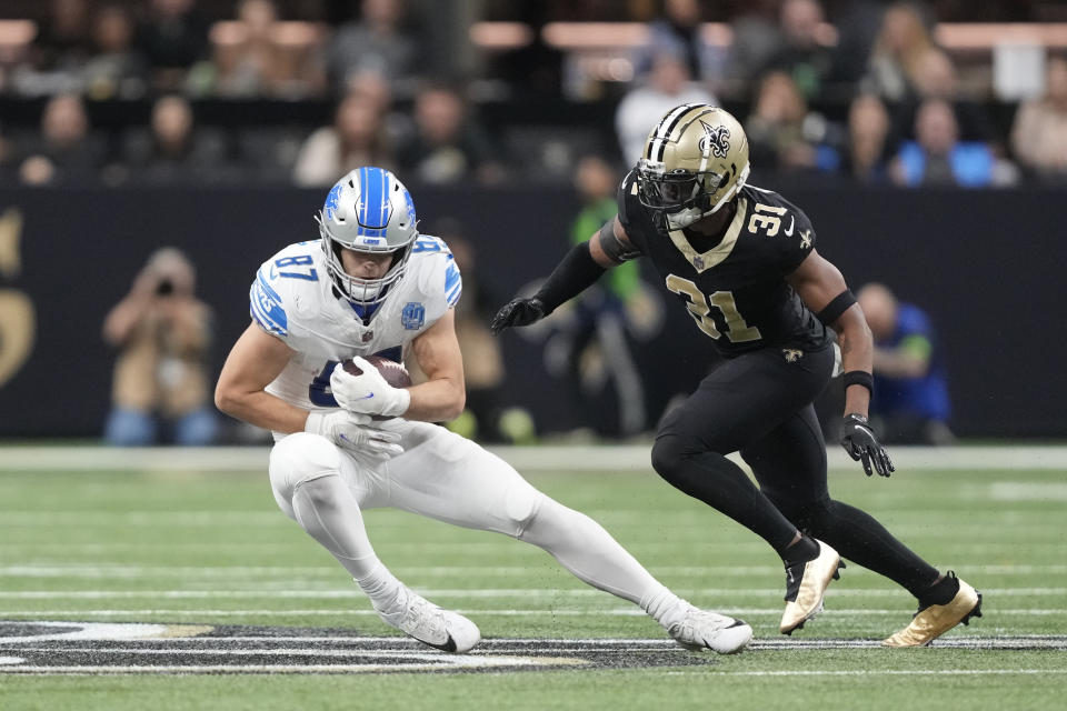 Detroit Lions tight end Sam LaPorta (87) makes a catch as New Orleans Saints safety Jordan Howden (31) defends during the first half of an NFL football game, Sunday, Dec. 3, 2023, in New Orleans. (AP Photo/Gerald Herbert)