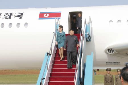 North Korean leader Kim Jong Un and his wife Ri Sol Ju disembark from a plane as they arrive for the 2014 Combat Flight Contest among commanding officers of the Korean People's Air Force in this undated photo released by North Korea's Korean Central News Agency (KCNA) in Pyongyang May 10, 2014. REUTERS/KCNA