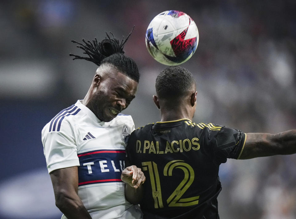 Vancouver Whitecaps' Sam Adekugbe, left, and Los Angeles FC's Diego Palacios (12) vie for the ball during the first half in Game 2 of a first-round MLS playoff soccer match in Vancouver, British Columbia, Sunday, Nov. 5, 2023. (Darryl Dyck/The Canadian Press via AP)