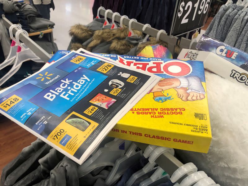 FILE PHOTO: Black Friday ads lay on top of clothes during a sales event on Thanksgiving day at Walmart in Westbury, New York