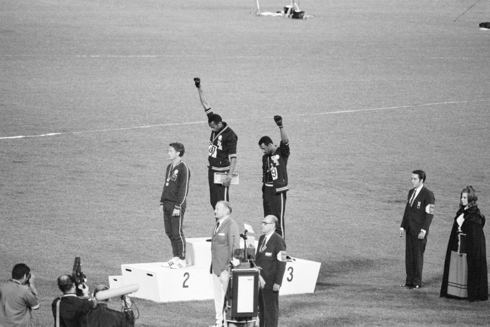 Tommie Smith y John Carlos, medallistas de oro y bronce en los 200 metros en las Olimpiadas de México 1968  alzan sus puños. (Foto: Getty Images)