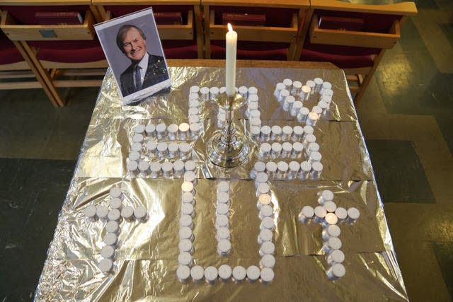 Candles and a photo at a vigil at St Michael's & All Angels church (Kirsty O'Connor/PA)