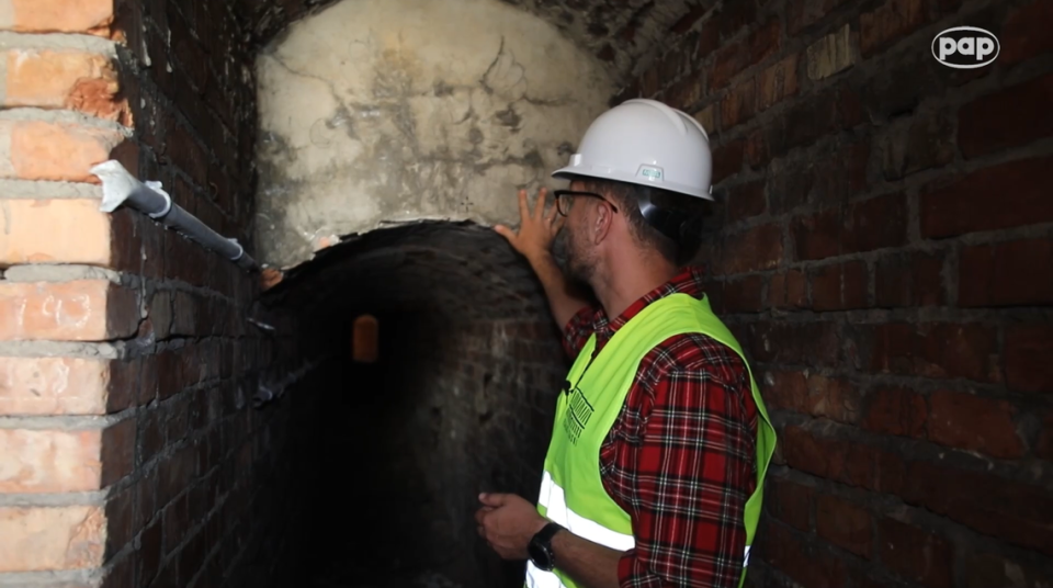 An archaeologists looks into the tunnel.