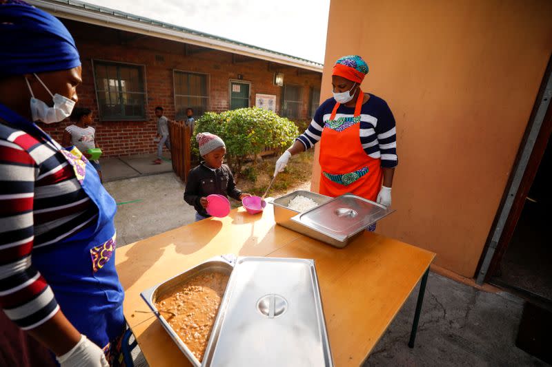 Volunteers and teachers serve food at a school feeding scheme in Gugulethu township during a nationwide lockdown aimed at limiting the spread of coronavirus disease (COVID-19) in Cape Town