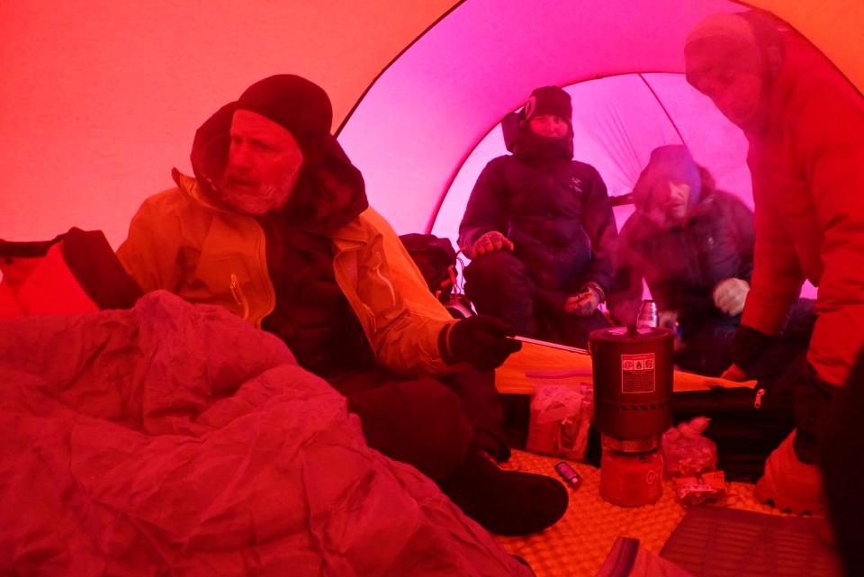 Jason Lance in the tent with mountain guides who had provided him, Sarah Maynard, and Grant Wilson with food and shelter at High Camp after their ordeal.