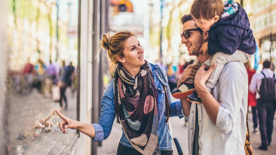 Photo of young happy family shopping around the city.