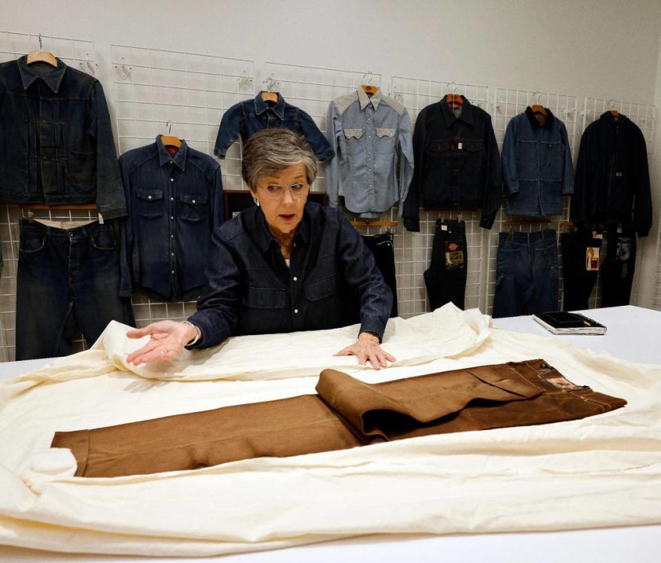 Archivist Ann Richardson talks about how a pair of pants were died in the early years with mineral oil at Dickies Quality Workwear and Apparel offices in downtown Fort Worth Texas, Thursday Mar. 28, 2024. The pants from 1928 were never worn.