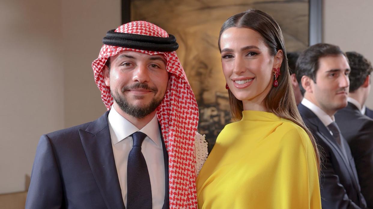 Prince Hussein standing with Princess Rajwa, who wears a yellow dress