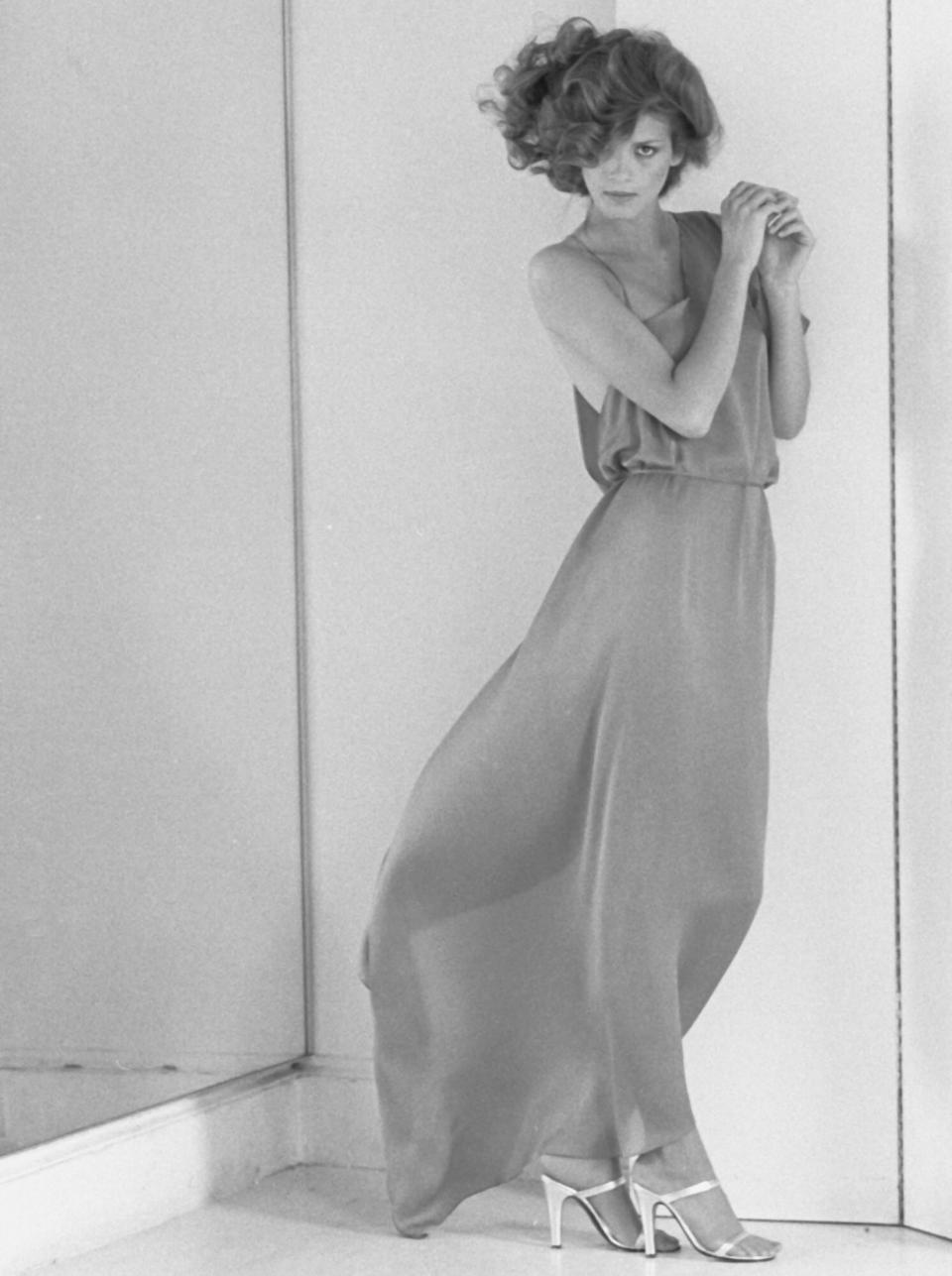 Full-length portrait of American fashion model Gia Carangi (1960 - 1986) as she poses in a semi-transparant, floor-length dress, from a Vogue magazine photoshoot, late 70s or early 80s. (Photo by Andrea Blanch/Getty Images)