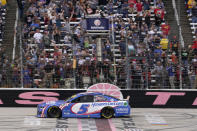Kyle Larson (5) takes the checkered flag to win a NASCAR Cup Series auto race at Texas Motor Speedway Sunday, Oct. 17, 2021, in Fort Worth, Texas. (AP Photo/Larry Papke)