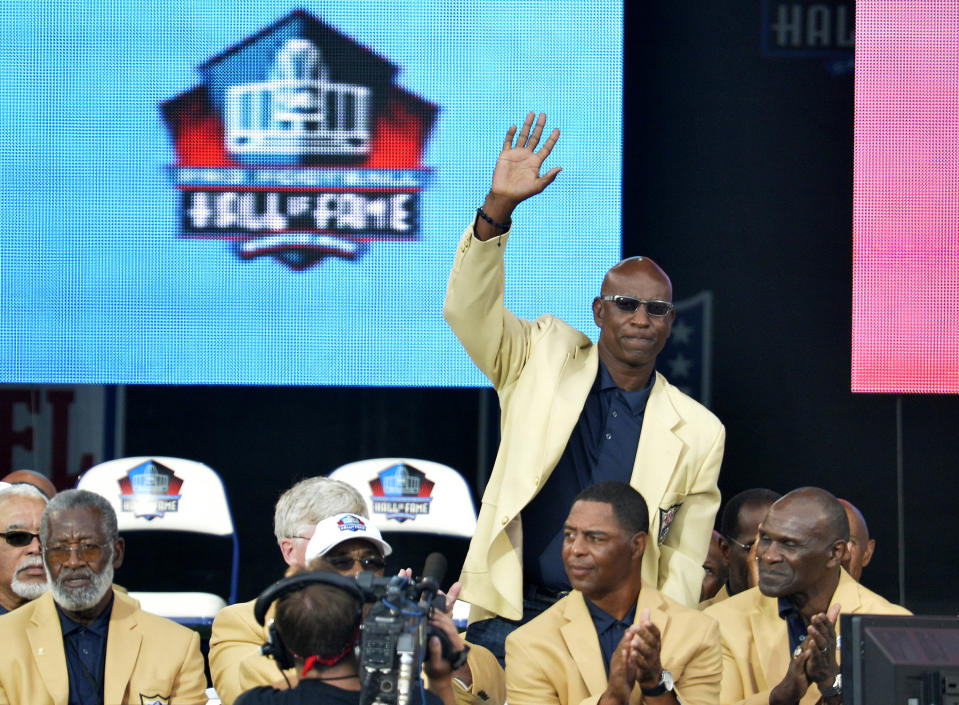 FILE - In this Aug. 2, 2014, file photo, enshrinee Eric Dickerson is introduced during the Pro Football Hall of Fame enshrinement ceremony, in Canton, Ohio. A group of Pro Football Hall of Famers is demanding health insurance coverage and a share of NFL revenues or else those former players will boycott the induction ceremonies. In a letter sent to NFL Commissioner Roger Goodell, NFLPA Executive Director DeMaurice Smith and Hall of Fame President David Baker — and obtained by The Associated Press — 21 Hall of Fame members cited themselves as "integral to the creation of the modern NFL, which in 2017 generated $14 billion in revenue." Among the signees were Eric Dickerson. (AP Photo/David Richard, File)