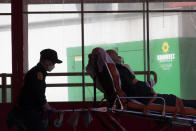 Emergency medical technicians transport a patient to Elmhurst Hospital Center emergency room, Saturday, April 4, 2020 in the Queens borough of New York. The new coronavirus causes mild or moderate symptoms for most people, but for some, especially older adults and people with existing health problems, it can cause more severe illness or death. (AP Photo/Mary Altaffer)