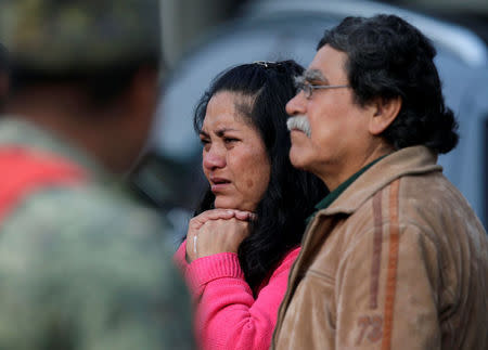 Family members of people still buried under the rubble of a collapsed building stand together near the site, after an earthquake in Mexico City, Mexico September 26, 2017. REUTERS/Jose Luis Gonzalez