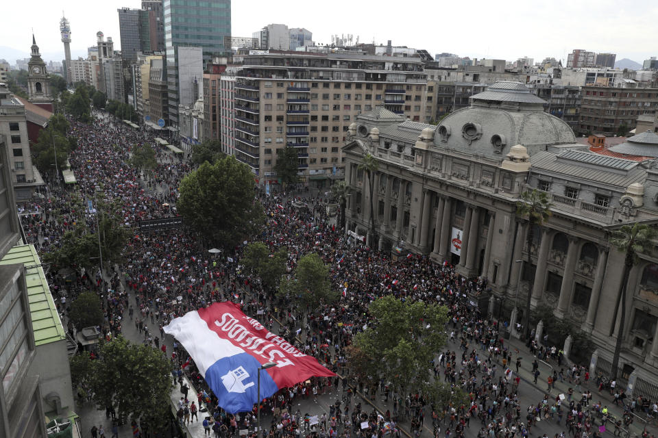 Anti-government demonstrators march in Santiago, Chile, Friday, Oct. 25, 2019. A new round of clashes broke out Friday as demonstrators returned to the streets, dissatisfied with economic concessions announced by the government in a bid to curb a week of violence that began with a protest over a hike in subway fares. (AP Photo/Esteban Felix)