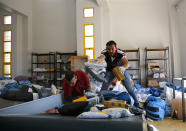 Palestinian postal workers sift through sacks of eight years' worth of undelivered mail held by Israel, at the post office in the West Bank city of Jericho, Sunday, Aug. 19, 2018. In recent days the postal staff has been sorting through tons of undelivered mail in a room packed with letters, boxes and even a wheelchair. Postal official Ramadan Ghazawi says Israel did not respect a 2008 agreement to send and receive mail directly through Jordan. Israeli officials say the one-time release of 10.5 tons of mail was a "gesture." (AP Photo/Nasser Shiyoukhi)