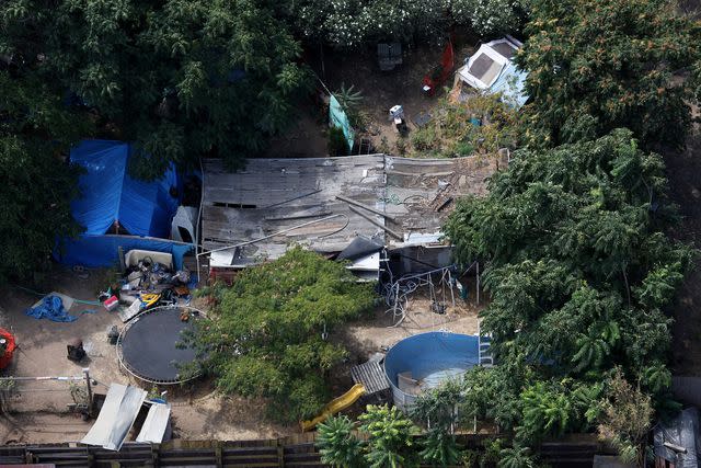 <p>Justin Sullivan/Getty</p> Tarps, tents and a wooden structure are seen in the backyard of alleged kidnapper Phillip Garrido on August 28, 2009.