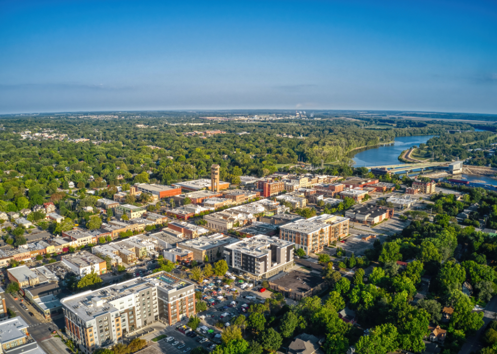 Aerial view of city buildings surrounded by green trees.