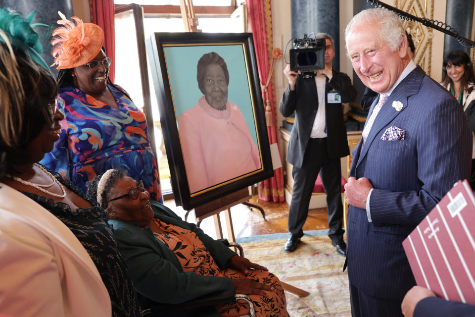 Britain's King Charles III (L) speaks with Edna Henry, alongside a portrait of them, during a reception to celebrate the Windrush Generation and mark the 75th anniversary of the arrival of the HMT Empire Windrush, at Buckingham Palace, in London, on June 14, 2023. During the reception, ten portraits of Windrush elders were unveiled. (Photo by Chris Jackson / POOL / AFP) (Photo by CHRIS JACKSON/POOL/AFP via Getty Images)