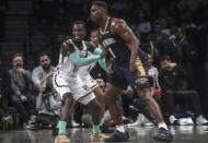 Brooklyn Nets' Dennis Schroder, left, pushes against New Orleans Pelicans' Zion Williamson during the first half of an NBA basketball game, Tuesday, March 19, 2024, in New York. (AP Photo/Bebeto Matthews)