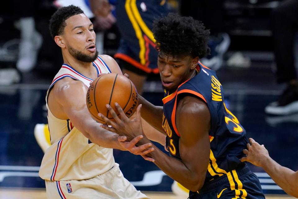Golden State Warriors center James Wiseman, right, is defended by Philadelphia 76ers guard Ben Simmons during the second half of an NBA basketball game in San Francisco, Tuesday, March 23, 2021. (AP Photo/Jeff Chiu)