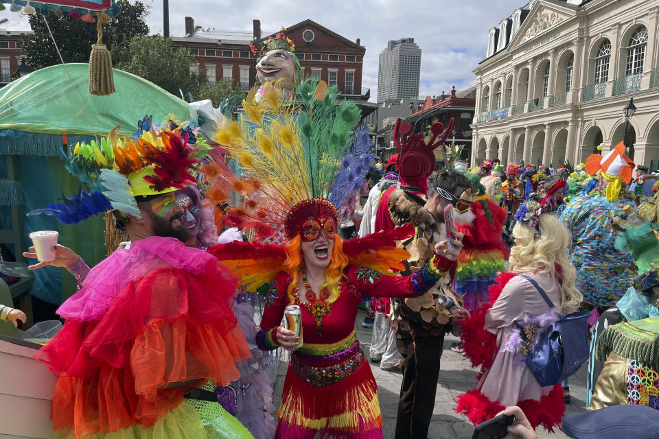 Revelers dance and take selfies in Jackson Square in New Orleans during Mardi Gras celebrations, Tuesday, Feb. 13, 2024. (AP Photo/Kevin McGill)