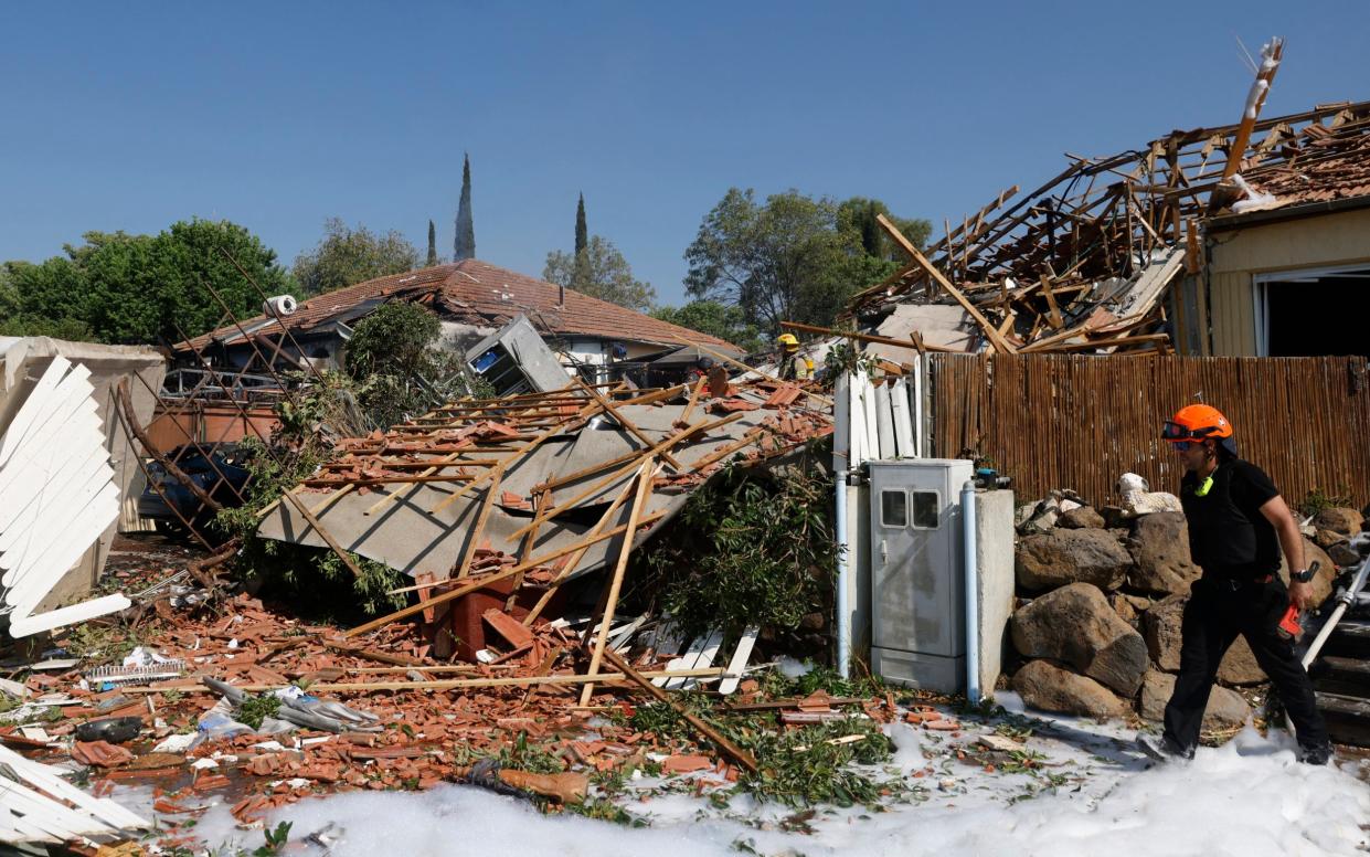 Firefighters inspect the damage in Katzrin in the Golan heights