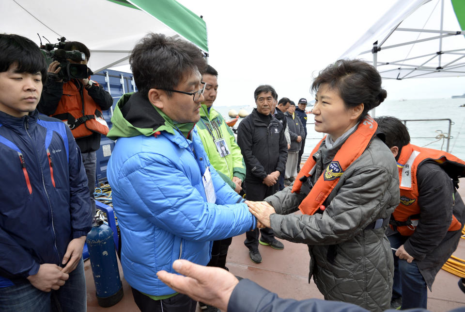 South Korean President Park Geun-hye, right, consoles a relative of a passenger aboard the sunken Sewol ferry at the site where the ship sank in waters off the southern coast near Jindo, South Korea, Sunday, May 4, 2014. Park told families of those missing in the sunken ferry that her heart breaks knowing what they are going through, as divers recovered two more bodies on Sunday. (AP Photo/Yonhap) KOREA OUT