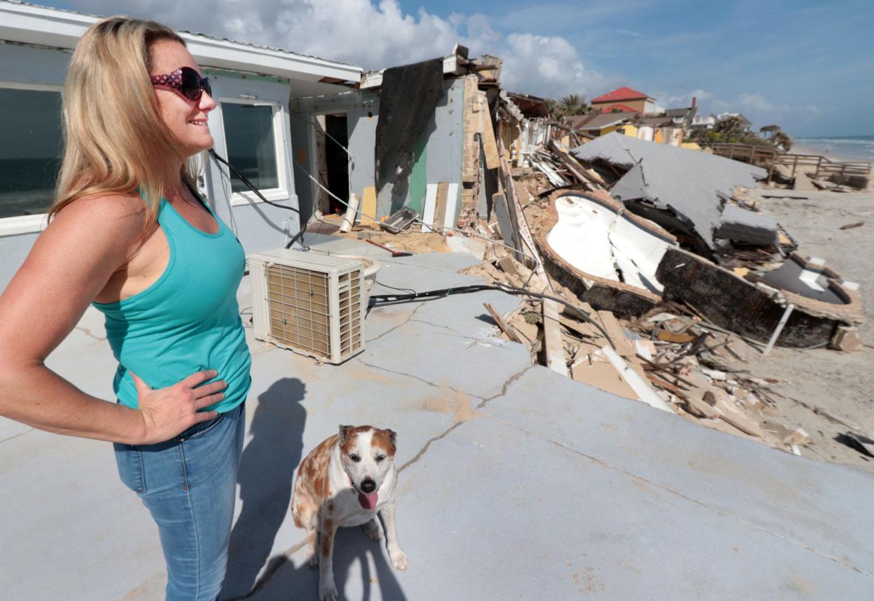 Salty Dog Vacations property manager Krista Goodrich stands on what's left of the deck of destroyed property at 4115 S. Atlantic Ave.