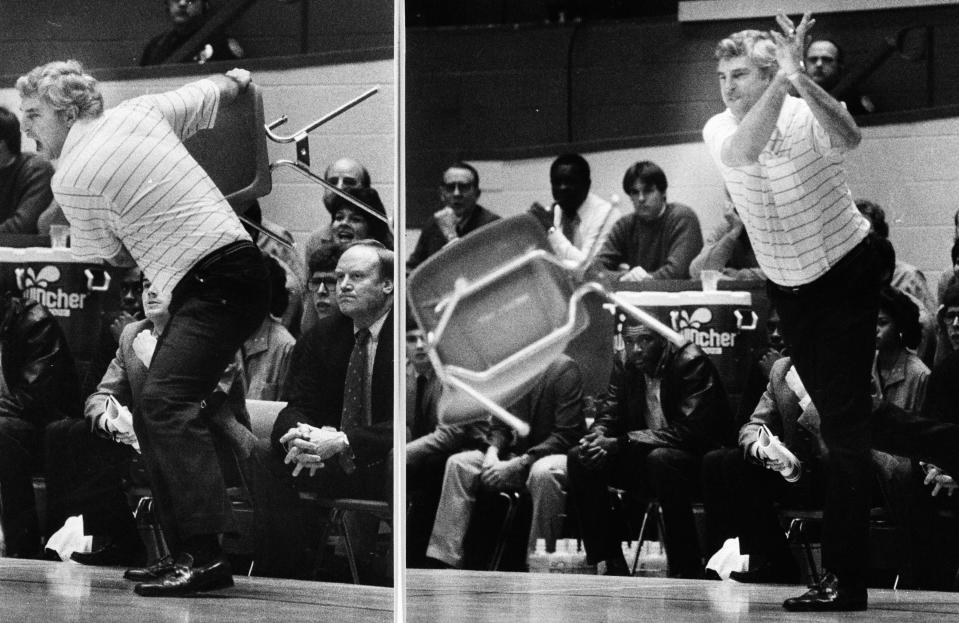 FILE - This Feb. 23, 1985, file photo shows Indiana coach Bob Knight winding up and pitching a chair across the floor during Indiana's 72-63 loss to Purdue, in Bloomington, Ind. Tony Hinkle turned Butler’s pass-and-cut offense of the 1920s into a coaching textbook for generations. Bob Knight and Gene Keady added their own revisions following Hinkle's forced retirement in 1970. Today, those three remain the gold standard of basketball innovation in Indiana, a state where successful coaches have spent more than a century testing novel concepts, breaking barriers and polishing philosophies before introducing them America.(AP Photo/File)