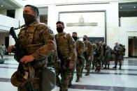 <p>Members of the National Guard walk through the Visitor Center of the U.S. Capitol on January 13, 2021 in Washington, DC</p>