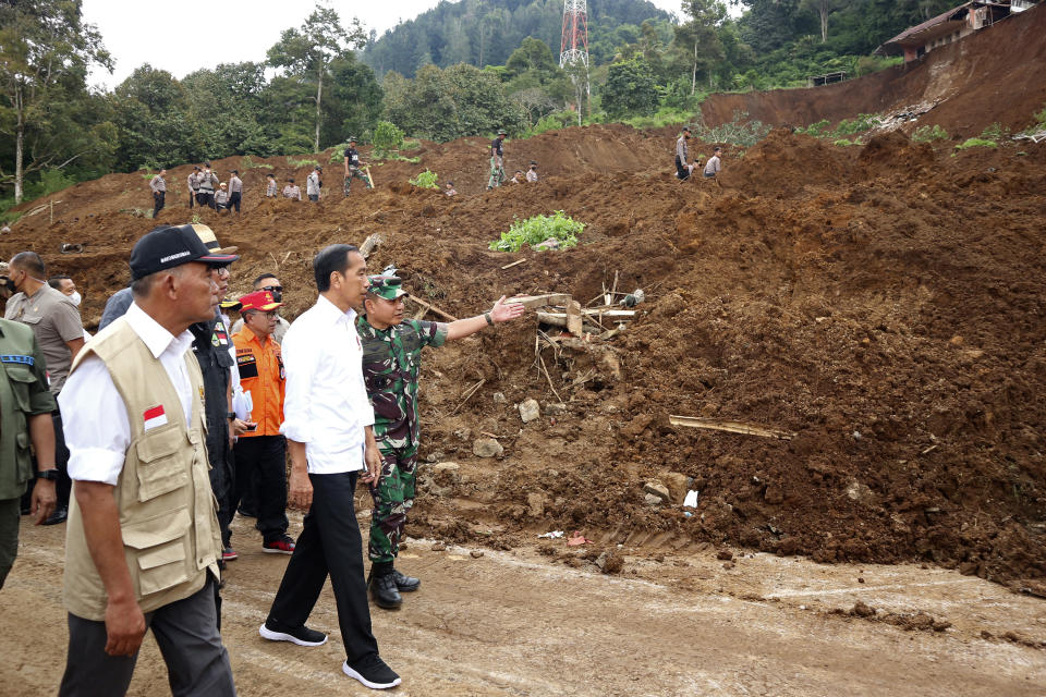 Indonesian President Joko Widodo, center, walks with Army Chief of Staff Gen. Dudung Abdurachman during their visit to a village affected by an earthquake-triggered landslide in Cianjur, West Java, Indonesia, Tuesday, Nov. 22, 2022. The earthquake killed hundreds of people and left hundreds more injured and missing on Indonesia's main island. (AP Photo/Rangga Firmansyah)