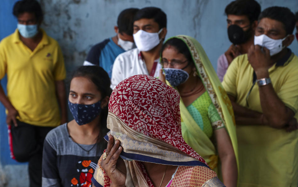 People wearing masks as a precaution against the coronavirus wait to test for COVID-19 at a hospital in Hyderabad, India, Monday, April 19, 2021. (AP Photo/Mahesh Kumar A.)