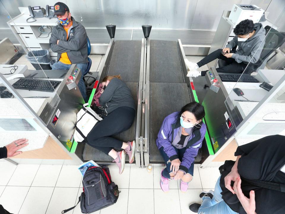 MISSISSAUGA, ON- APRIL 19 - Passengers sleep on conveyer belts. Passengers wait to be allowed onto their Sunwing flights after some have been delayed over a day at Toronto Pearson International Airport in Mississauga. April 19, 2022. Others have been stranded in Cuba, Mexico and Canada.