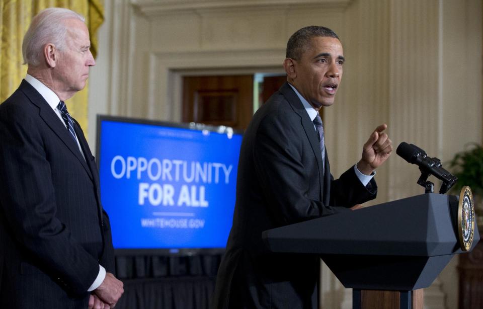 President Barack Obama, with Vice President Joe Biden standing left, gestures as he speaks in the East Room of the White House, Friday, Jan. 31, 2014, in Washington., about helping the long-term unemployed. (AP Photo/Carolyn Kaster)