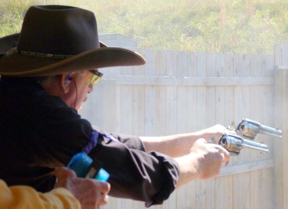Don Carlton, aka "Buck D. Law," is shown shooting during a competition. Carlton, who owns a printing business in Rainbow City, shoots in events sanctioned by the Single Action Shooting Society.
